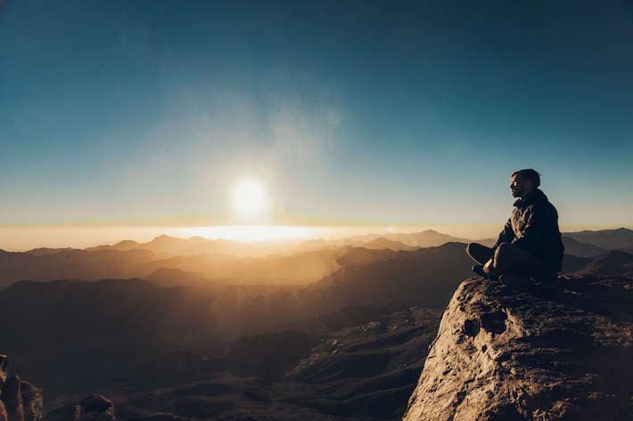 Meditating against background of beautiful sunrise, Mount Sinai, Egypt