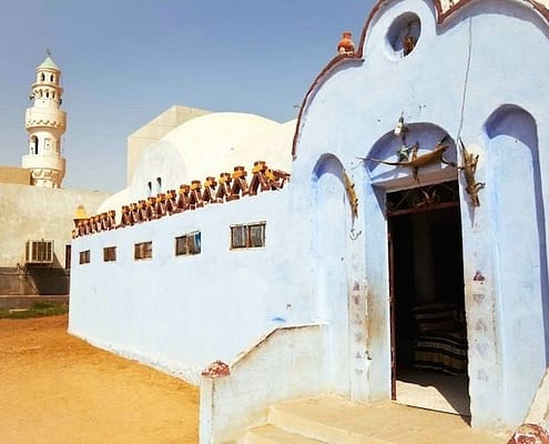 Nubian village, blue and white houses with a mosque in the background, Egypt.