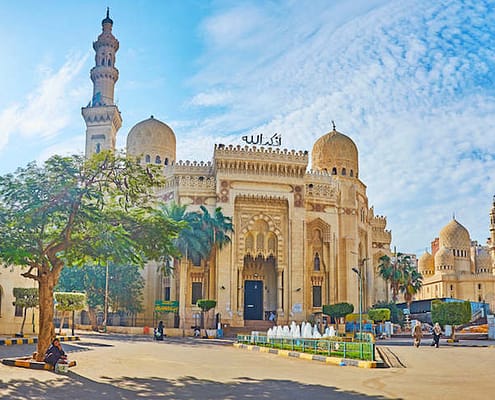 The carved stone facade of Abu al-Abbas al-Mursi Mosque with tall minaret and domes, decorated with complex patterns