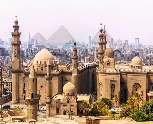 Egypt Cultural Tours - The Mosque of Sultan Hassan and the Pyramids in the background, Cairo, Egypt