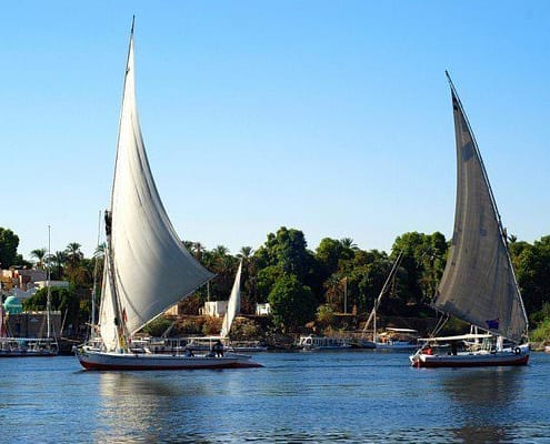 Two feluccas on the Nile River with Kitchener Island in the back, Aswan