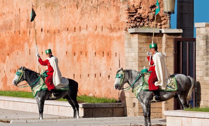 Places to visit in Rabat - Royal guard in front of Hassan Tower and Mausoleum of Mohammed V. Mausoleum contains tombs of late King Hassan II and Prince Abdallah. November 25, 2014 in Rabat, Morocco