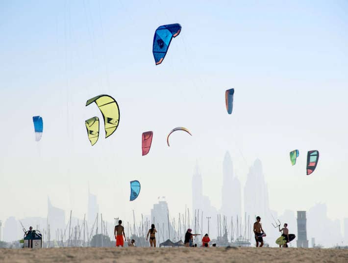 Kite beach in Jumeirah, Dubai, United Arab Emirates. A stretch of the beach designated for the kite surfers. The beach-goers are a colorful mix of different nationalities.