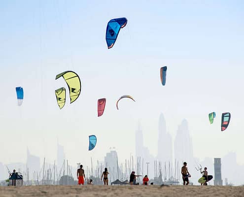 Kite beach in Jumeirah, Dubai, United Arab Emirates. A stretch of the beach designated for the kite surfers. The beach-goers are a colorful mix of different nationalities.